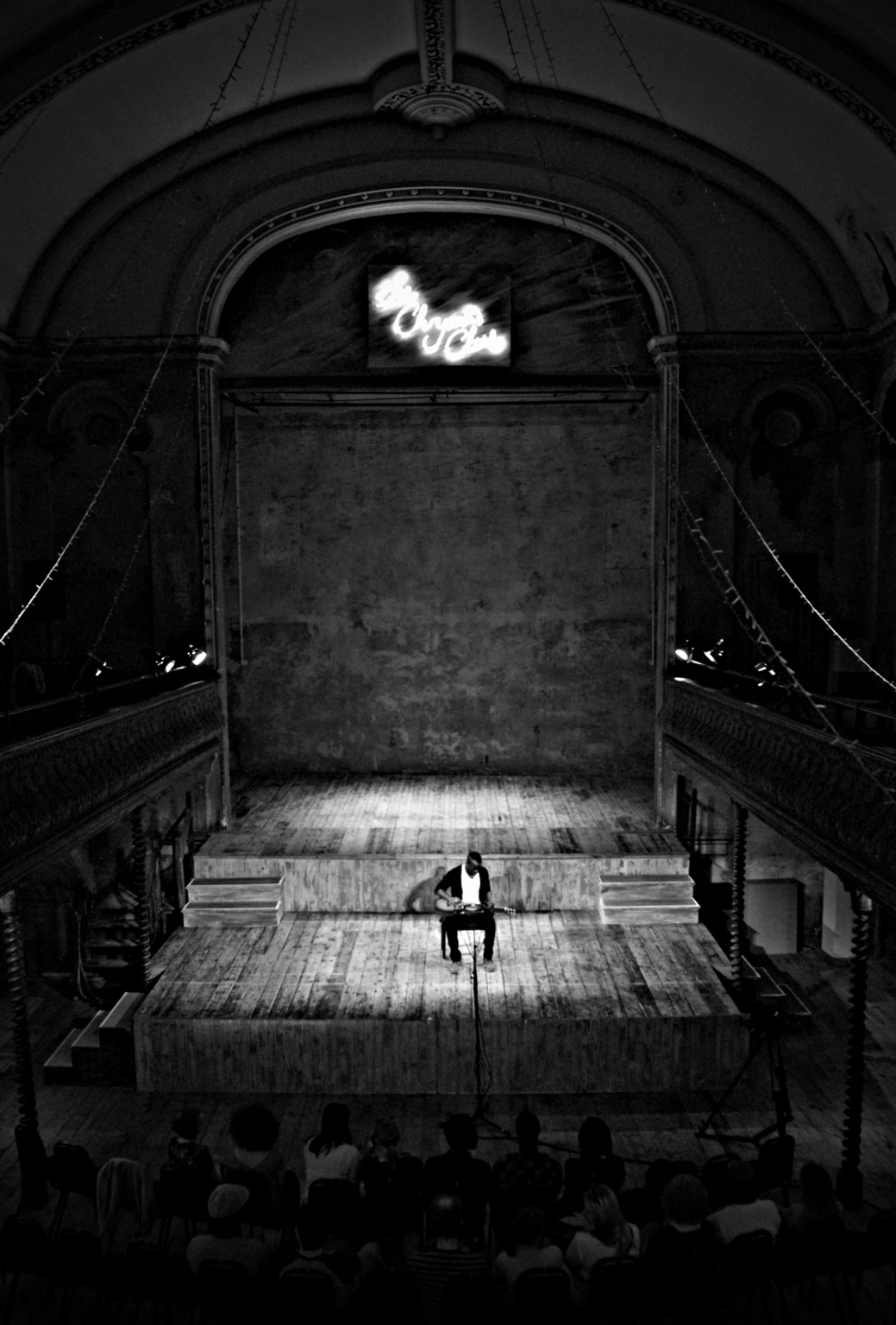 Black-and-white view of TJ performing beneath the arches at Wilton’s Music Hall