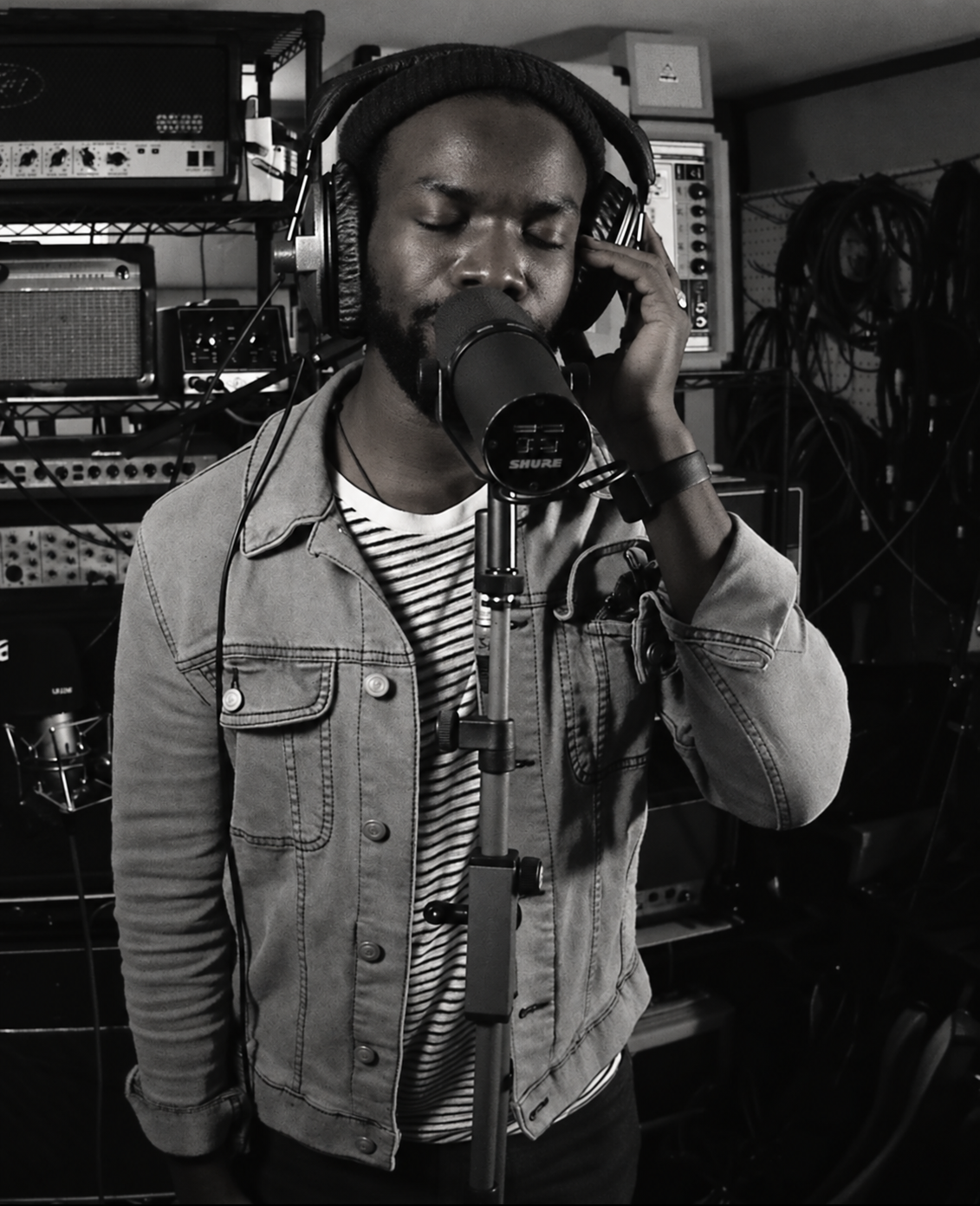 Black-and-white close view of TJ singing into a studio microphone